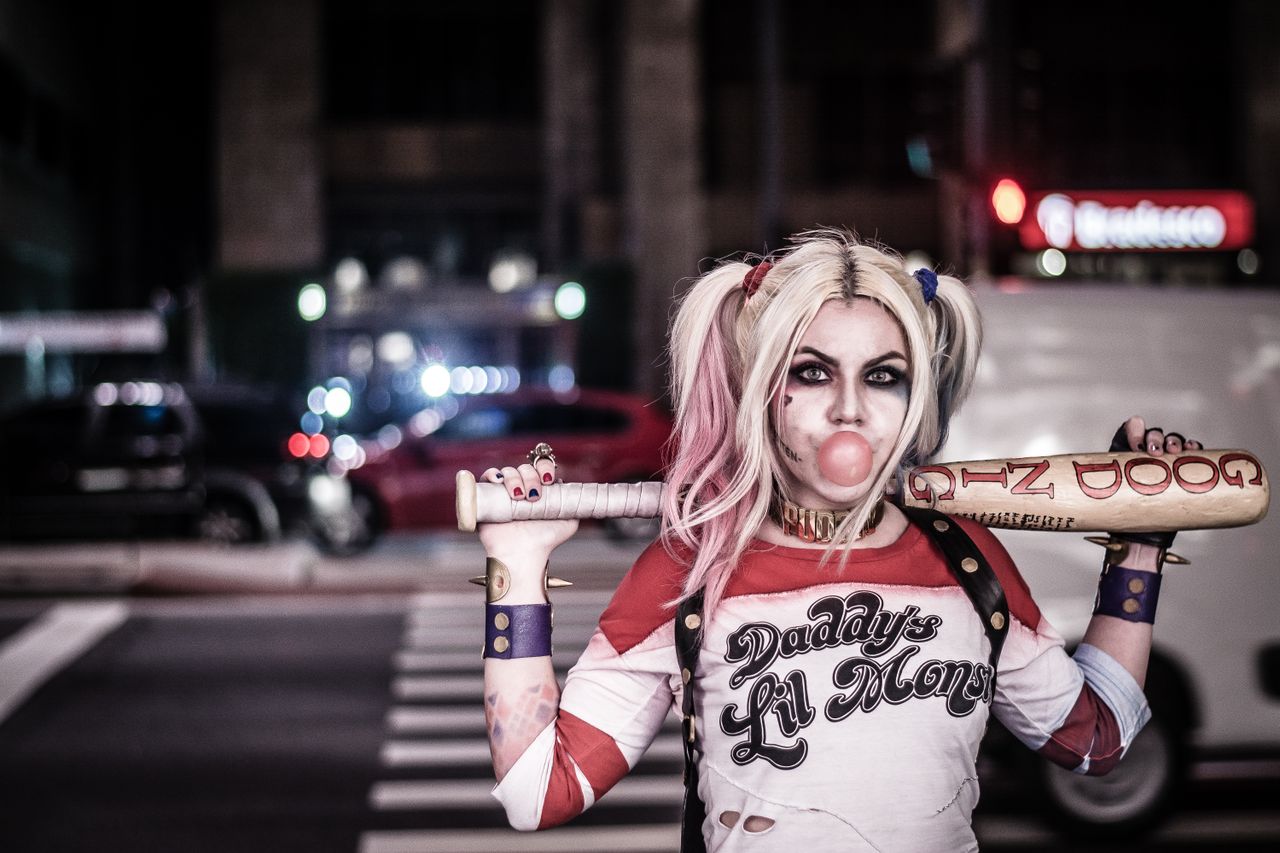 a woman in cosplay poses on a city street at night exuding a playful a