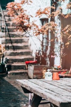 质朴的木桌、陶罐和灯笼，与迷人的秋天花园场景相映成趣