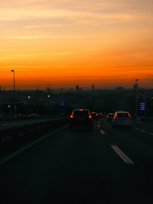 A sunset over a highway with cars driving on it