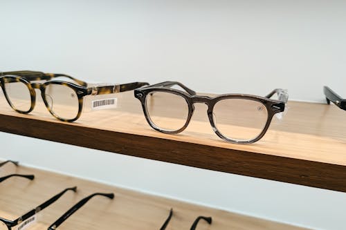 A row of glasses on a shelf with a wooden background