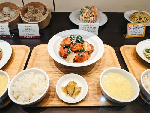 Free A variety of Asian dishes elegantly presented on wooden boards, featuring dumplings, rice, and a vibrant salad. Stock Photo
