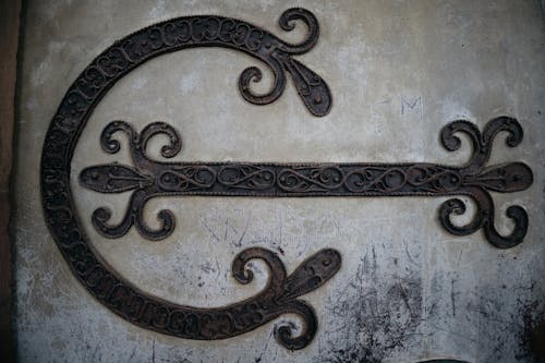 A decorative metal door handle with a large c