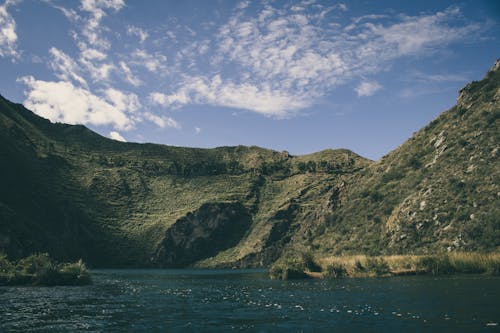 Landscape Photography of Hill Near Body of Water