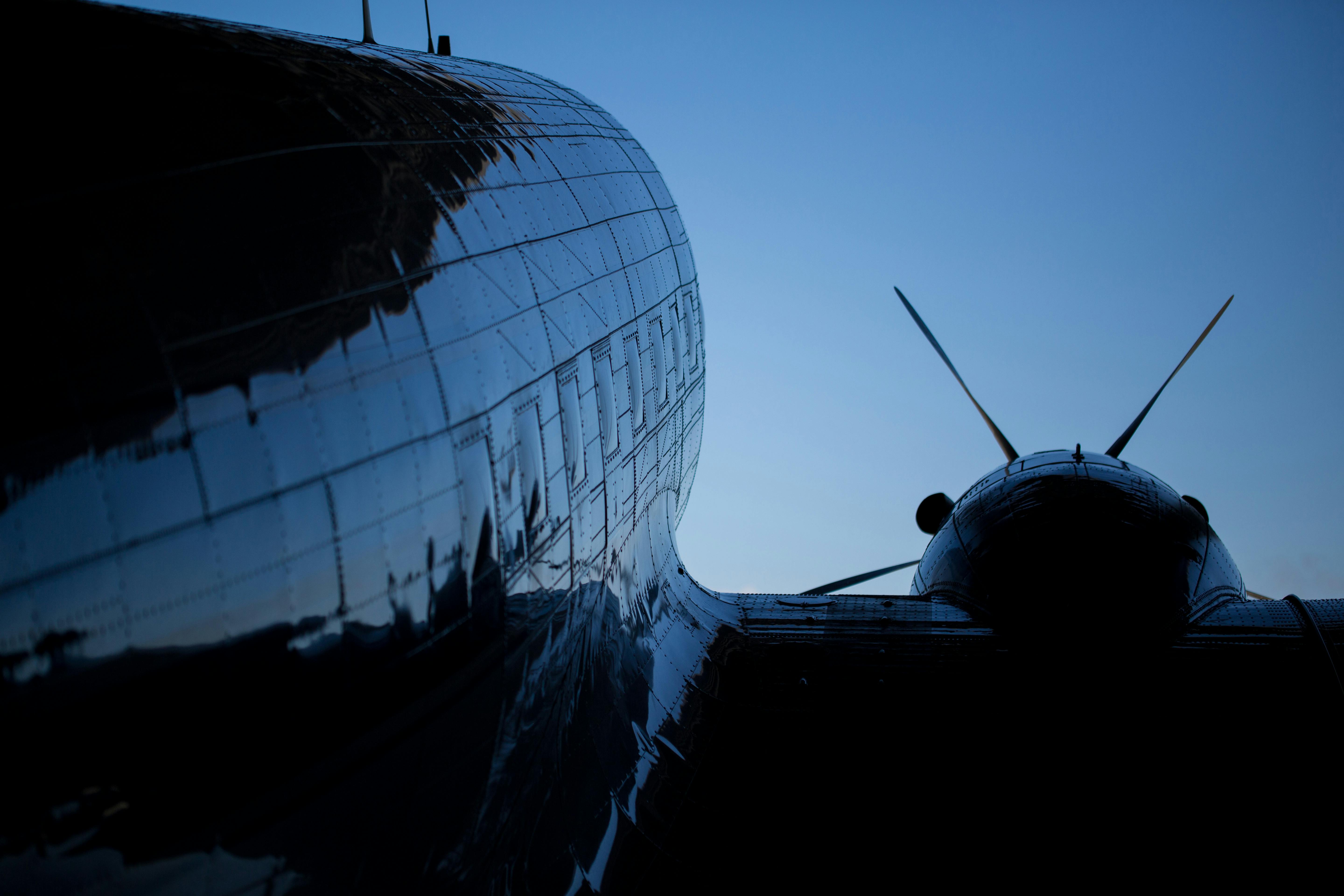 傍晚的天空中，一架老式螺旋桨飞机的轮廓，映出了反光体和螺旋桨