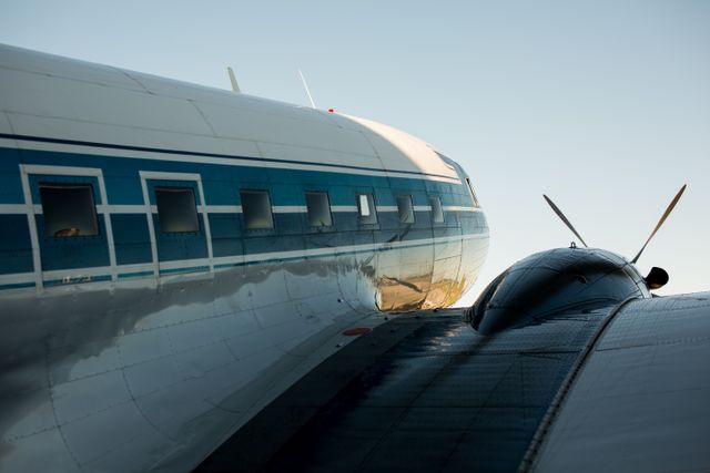 Close-up of a vintage propeller aircraft fuselage on the tarmac. Photo by K on Pexels