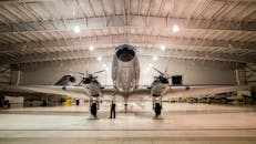 一架老式飞机在光线充足的机库中展示其前视图，体现了航空技术