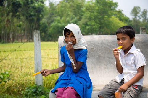 Photo of Two Children Eating Food