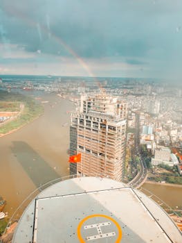 城市景观中，高层建筑与河景相映成趣，彩虹为这幅画面增添了活力
