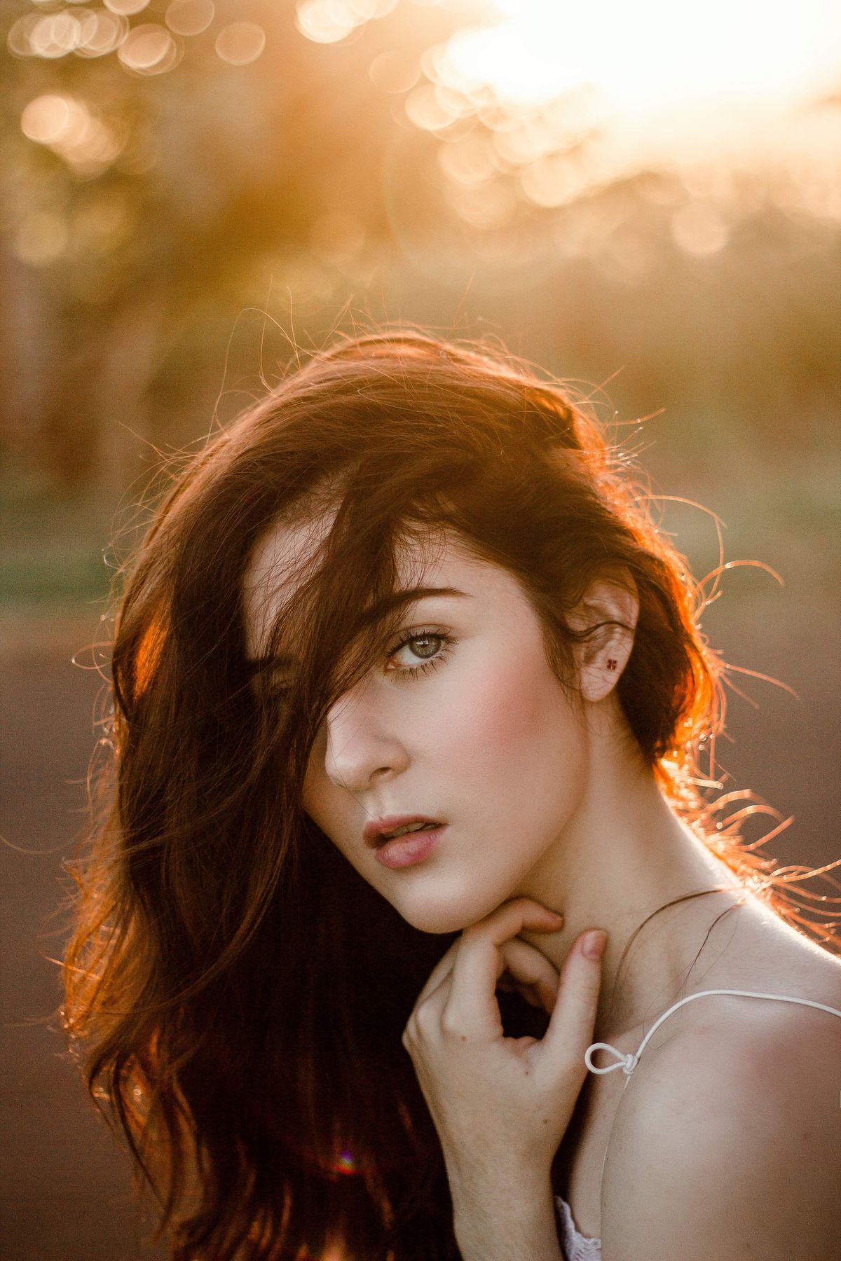 Close portrait of a woman glowing in warm backlight with soft bokeh