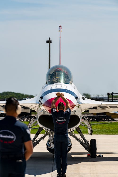 A man standing next to a fighter jet
