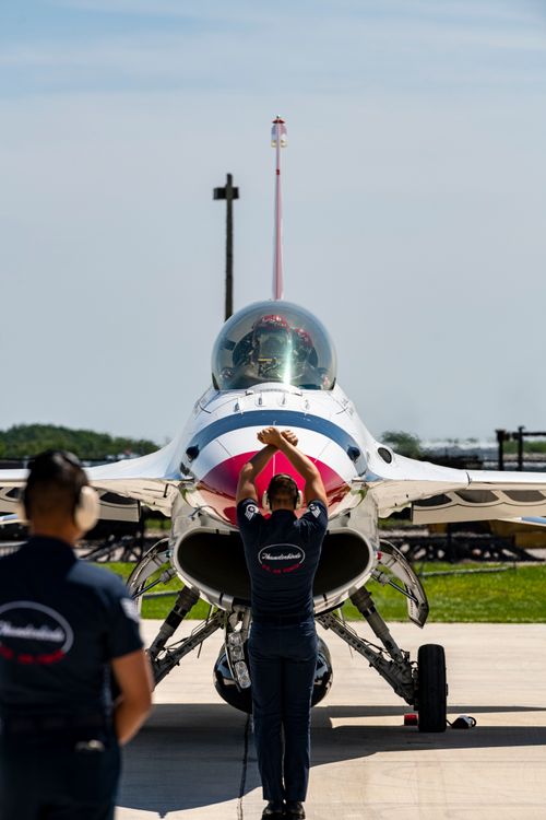 Free US Air Force Thunderbirds team preparing jet at airbase under sunny skies. Stock Photo