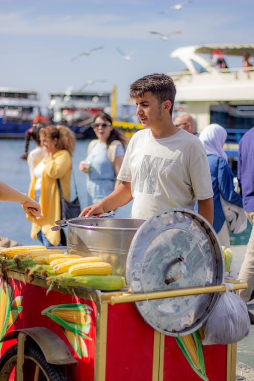 A man selling corn on the cob at a market