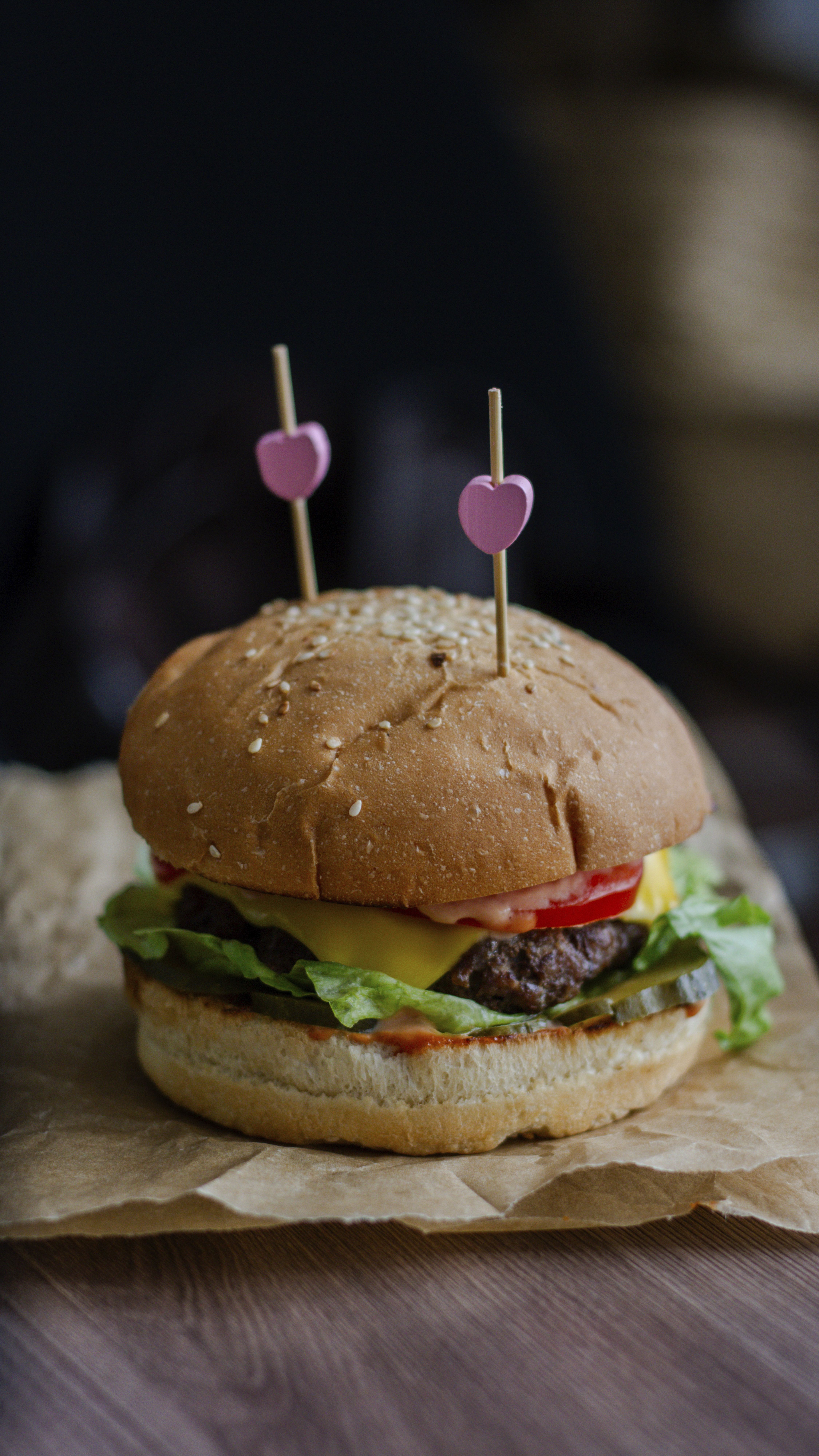 Close-up of a cheeseburger with heart decorations, perfect for fast food lovers.