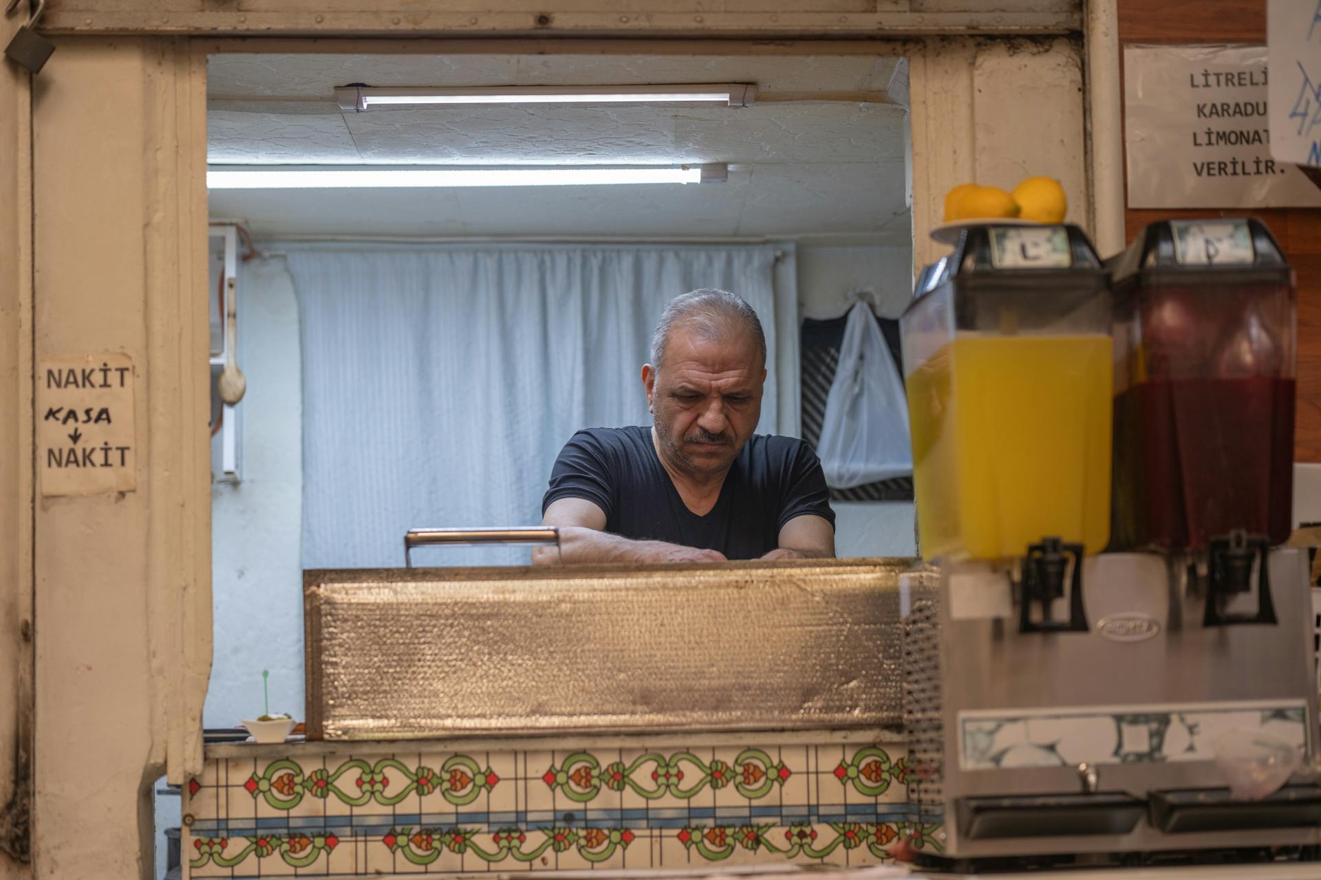 Senior Man behind Counter of Small Restaurant