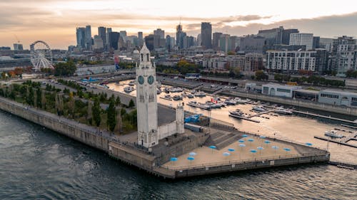 A large clock tower sits in the middle of a harbor