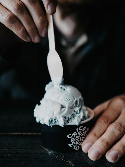 Free Close-up view of a person using a wooden spoon to scoop delicious ice cream. Stock Photo