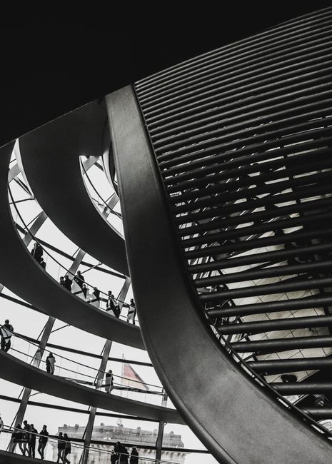 Captivating view of modern spiral interior architecture in Berlin with people ascending the structure.
