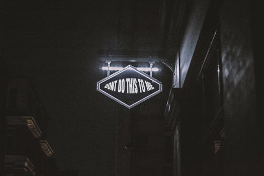 在昏暗的城市环境中，霓虹灯闪烁着“不要对我这样做”的信息