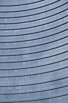 这张特写展示了米兰现代弧形玻璃建筑立面的时尚设计