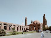 一座宏伟的清真寺，在晴朗的蓝天下展示着醒目的圆顶和尖塔，彰显了伊斯兰建筑的特色