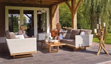 两名女子在绿植环绕的庭院中，手持吉他和蜡烛，享受着宁静的时光