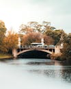 一座美丽的桥横跨宁静的河流，四周是充满活力的秋叶，共同构成了一幅秀丽的秋日风景
