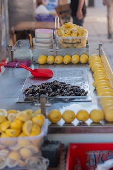 Vibrant street food stall in İzmir displaying fresh lemons and stuffed mussels.