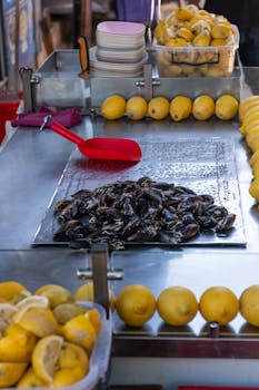 Explore a vibrant street food scene in İzmir with stuffed mussels and fresh lemons on display.