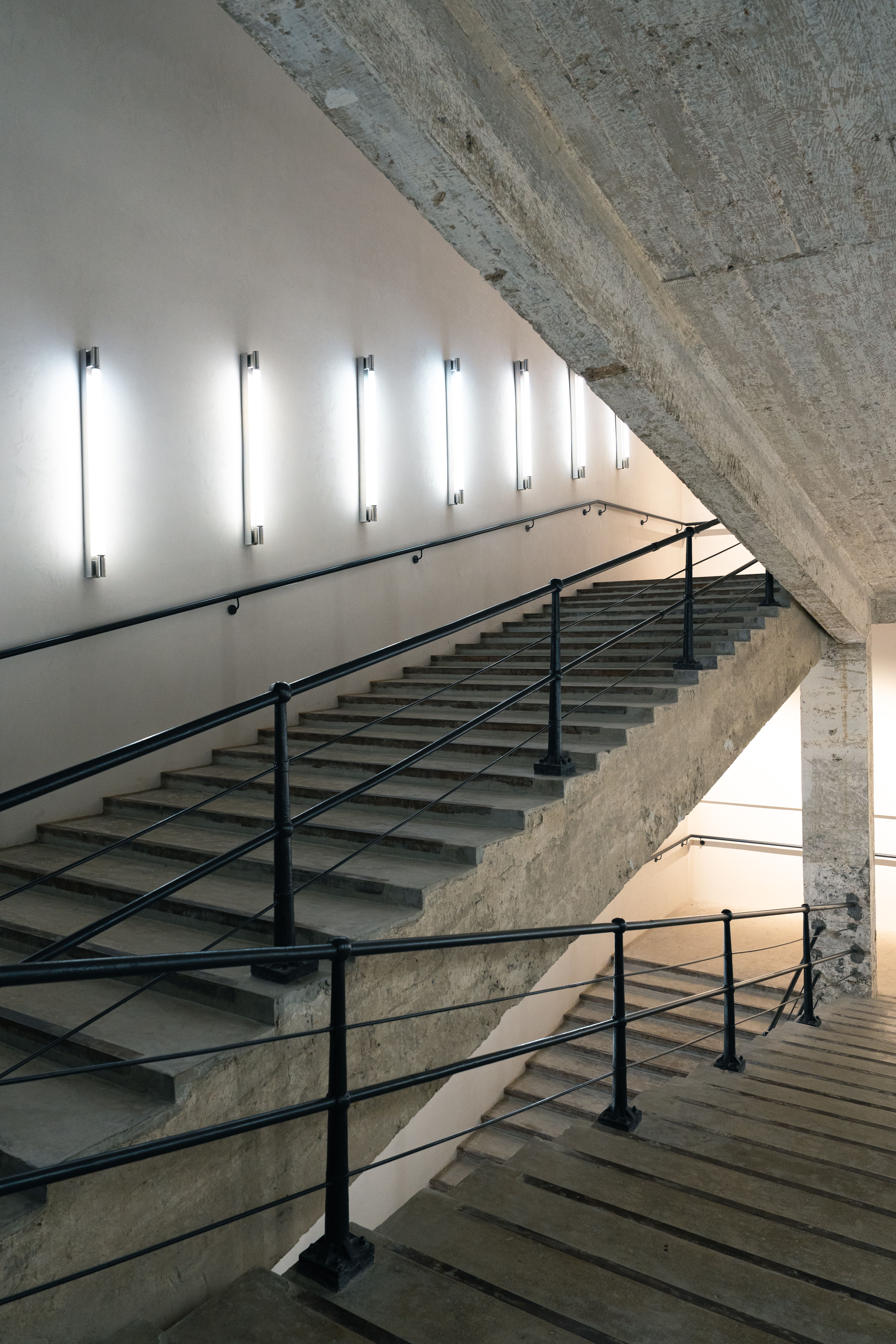 Sleek industrial staircase with concrete and metal details in modern interior.