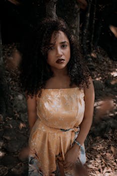 在自然环境中，一位时尚女性散发着优雅与内省的气质