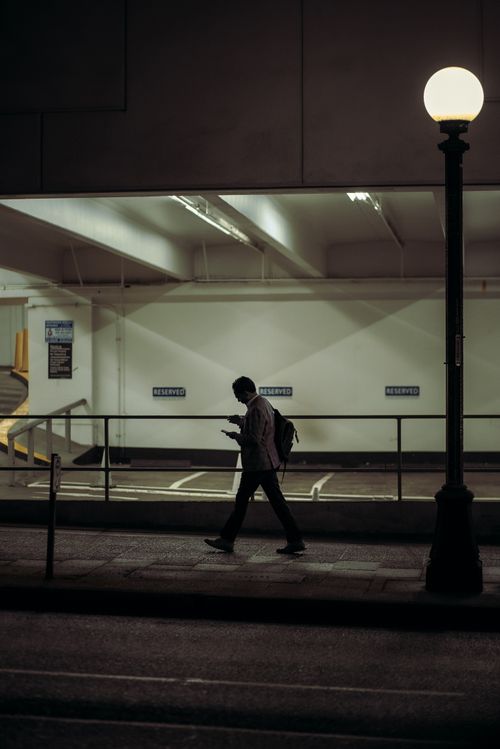 Free A person walking by a street lamp at night in an urban setting in Seattle. Stock Photo