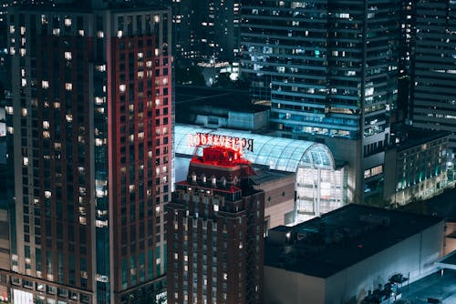 A city skyline with a red building lit up at night