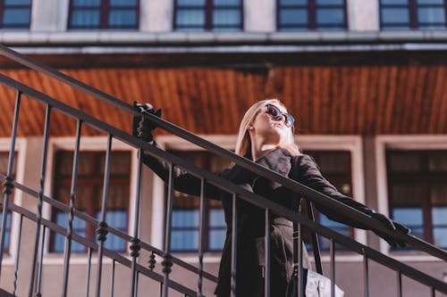 Woman Wearing Black Coat Touching Black Handrail