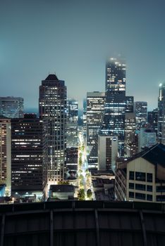 Stunning night view of Seattle's illuminated skyscrapers from a rooftop vantage point.