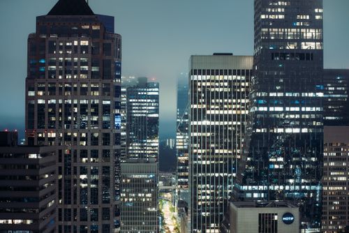 Free Seattle's modern skyscrapers lit up at night in fog, showcasing urban architecture. Stock Photo