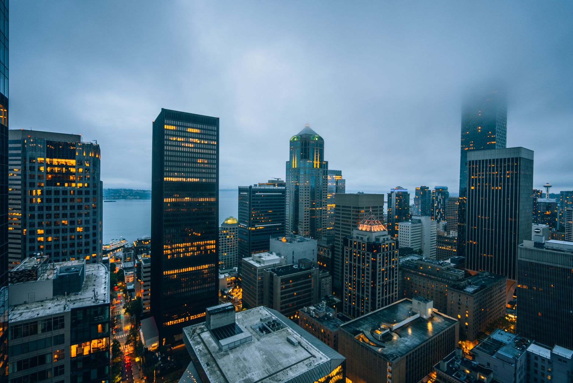 Stunning aerial view of foggy skyscrapers in downtown Seattle at twilight, showcasing modern architecture.