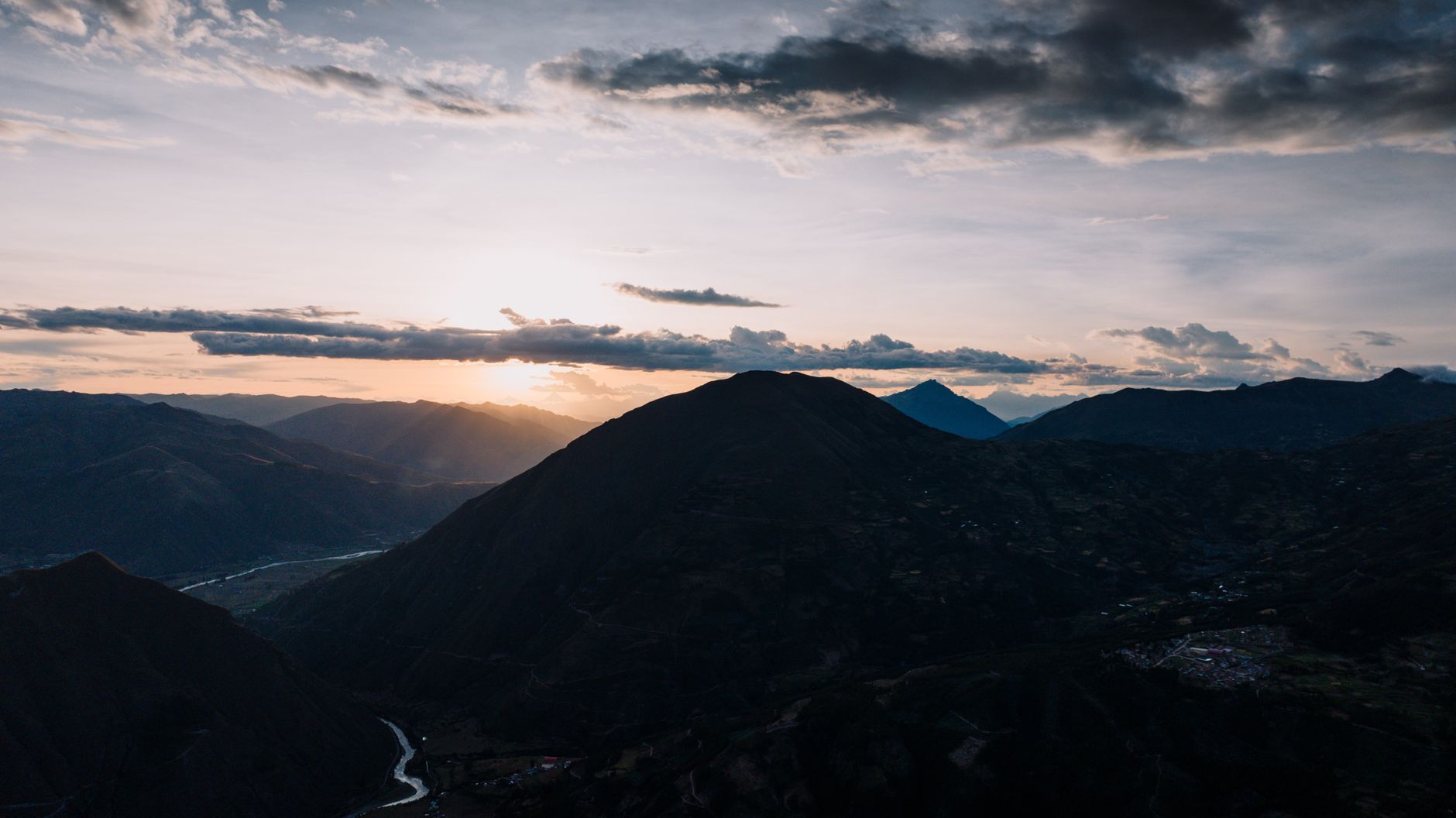 A breathtaking aerial view of the sunset over mountains and valleys in Cusco, Peru.