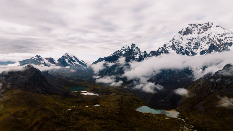 Incredible Nazca Land Archeological Tour Review: An Unforgettable 8-Hour Journey Through Peru's Ancient Mysteries Review 2026 - Aerial view of snow-capped Andes mountains and valley in Cusco, Peru, with clouds and lakes.