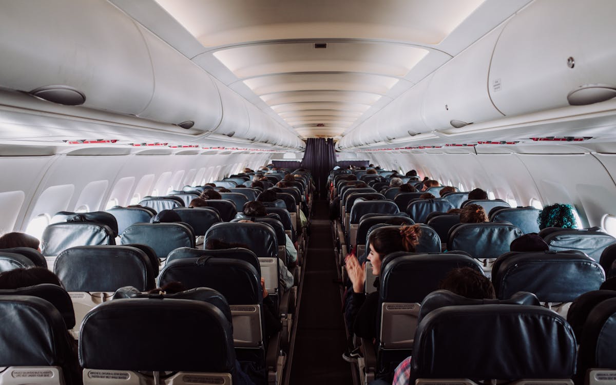 A view of passengers seated inside a commercial airplane cabin during flight.