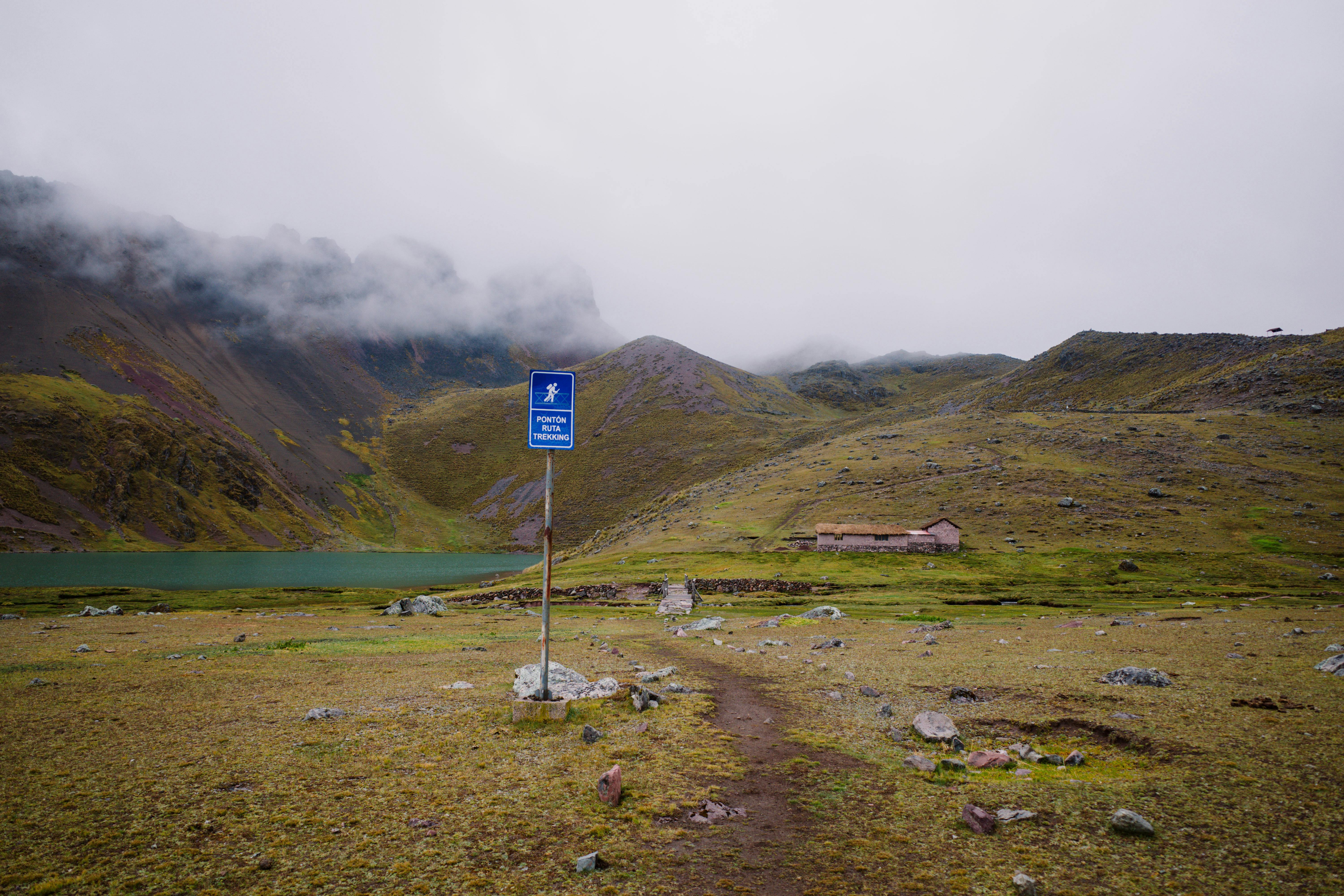 Scenic mountain view in Pajchanta, Qosqo, Peru with foggy peaks and a serene trekking path.