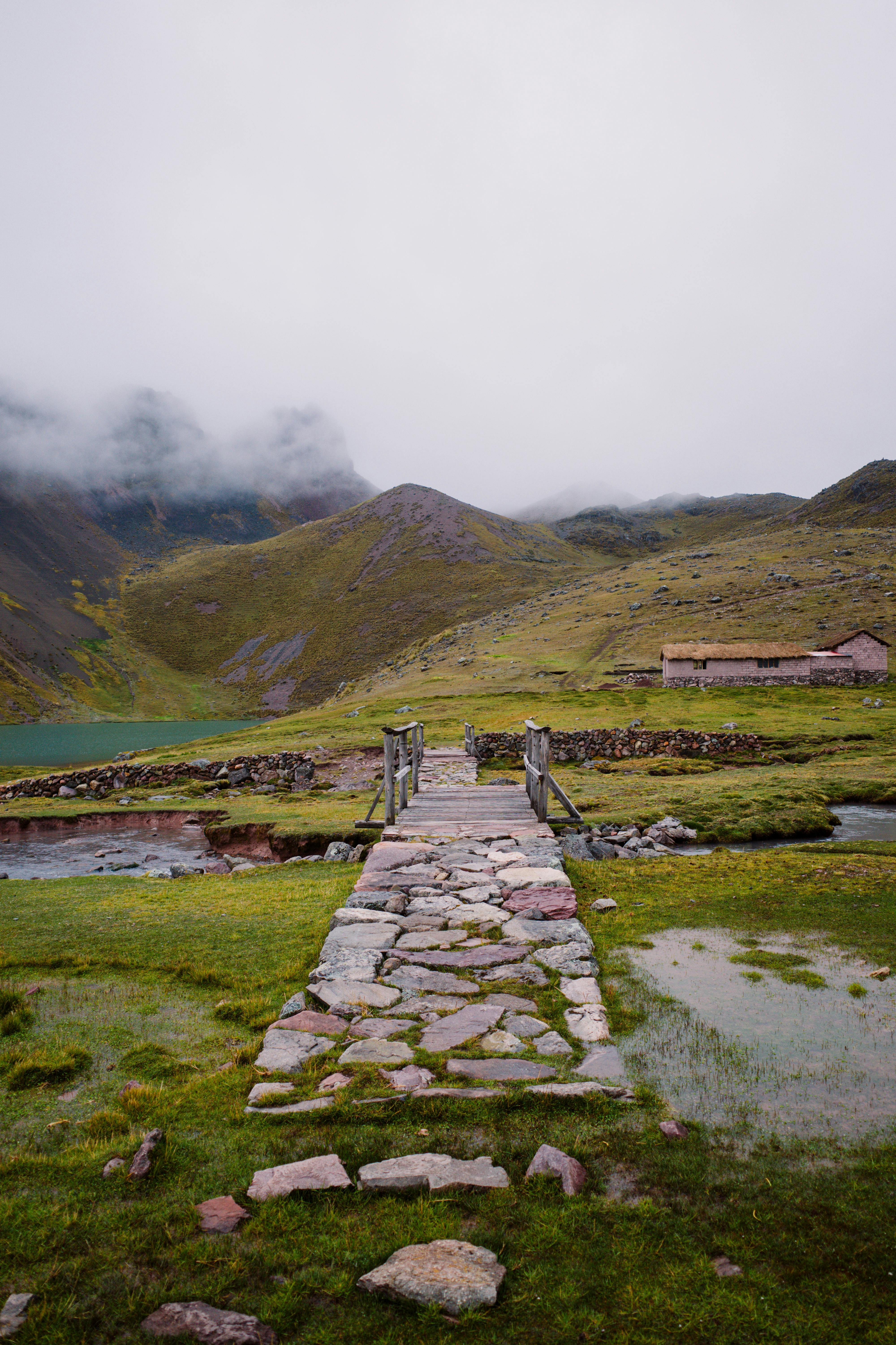 Scenic view of a stone bridge leading to misty mountains in Pajchanta, Peru.