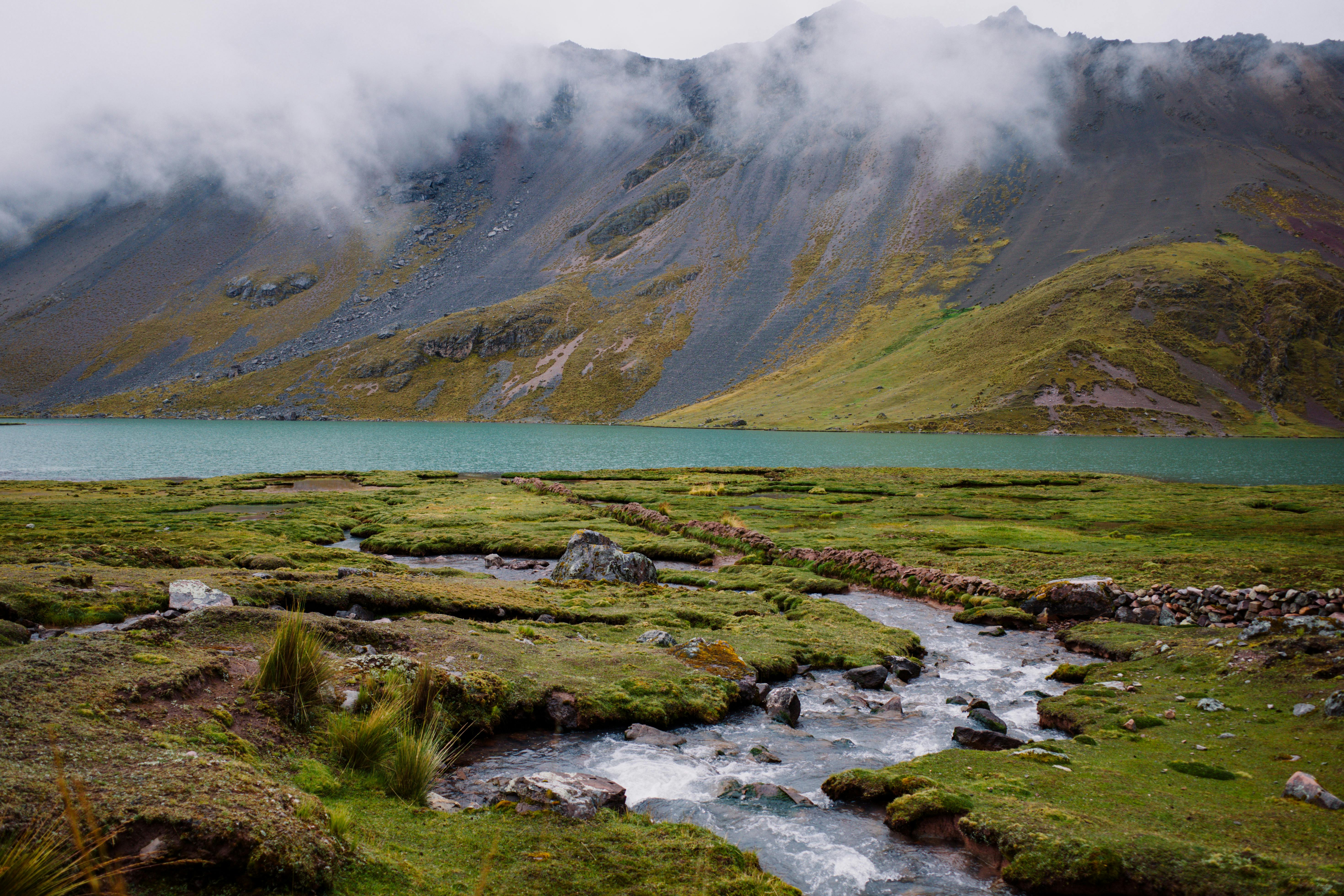 Serene landscape of a fog-covered mountain and lake in Pajchanta, Peru.
