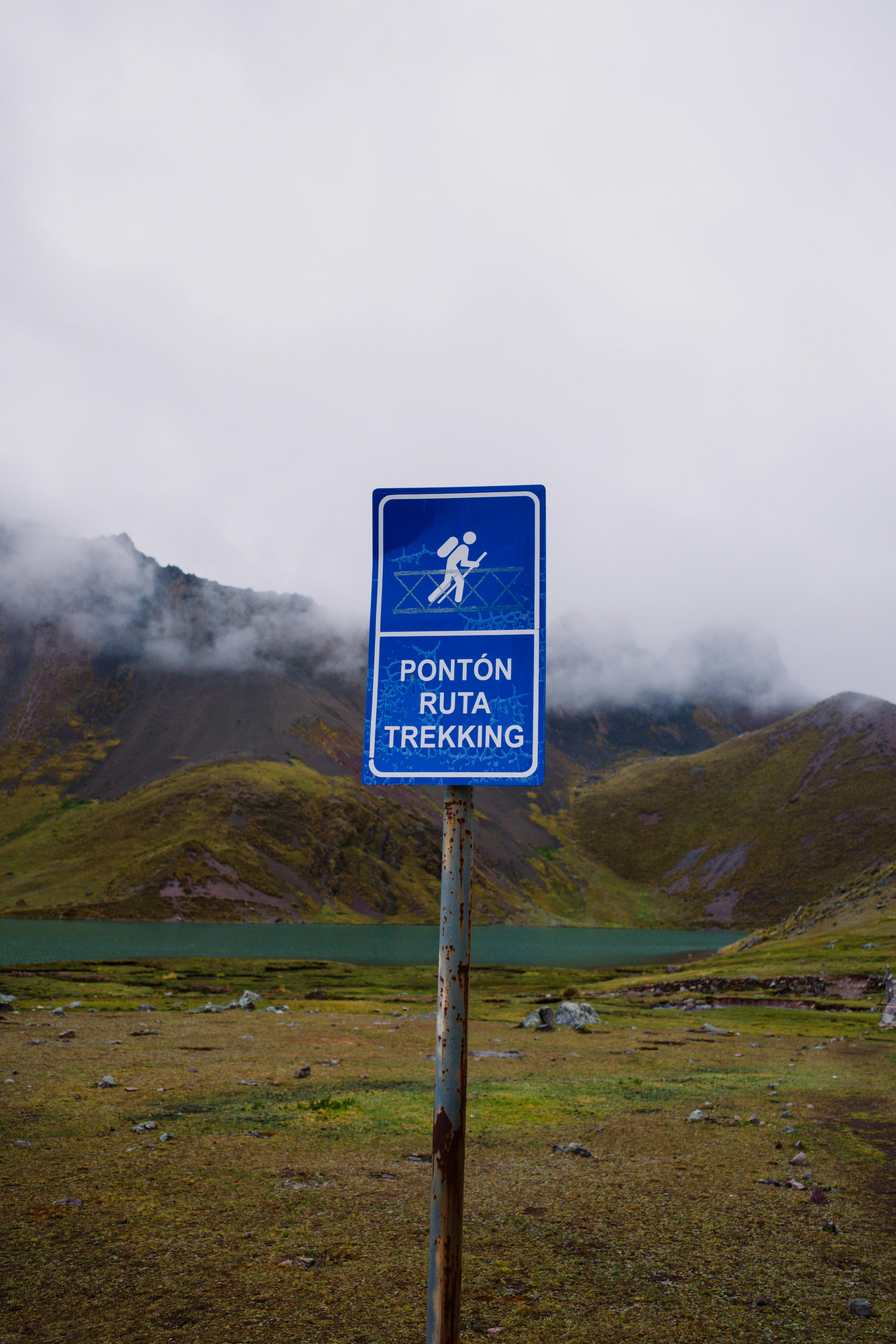 Trekking route sign against mountainous landscape in Pajchanta, Peru.