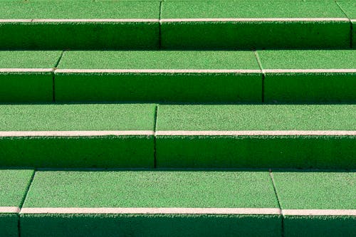 A green concrete step with a white line