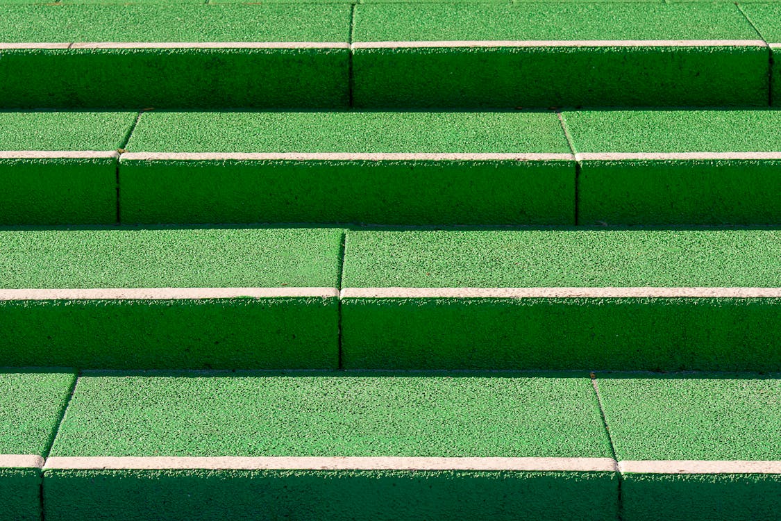 A green concrete step with a white line