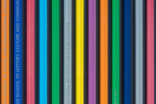 Vibrant multi-colored vertical stripes on a modern building facade, showcasing bold architectural design.