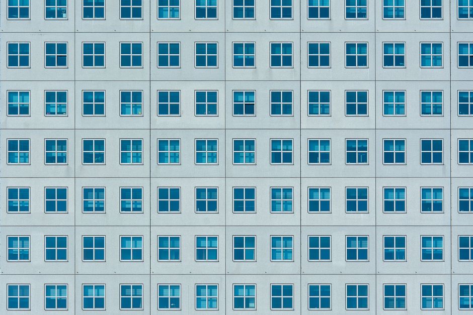 Symmetrical building facade with blue windows in Rotterdam, Netherlands.