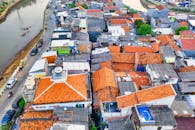 航拍照片中，蜿蜒的河流旁，茂密的村庄屋顶清晰可见