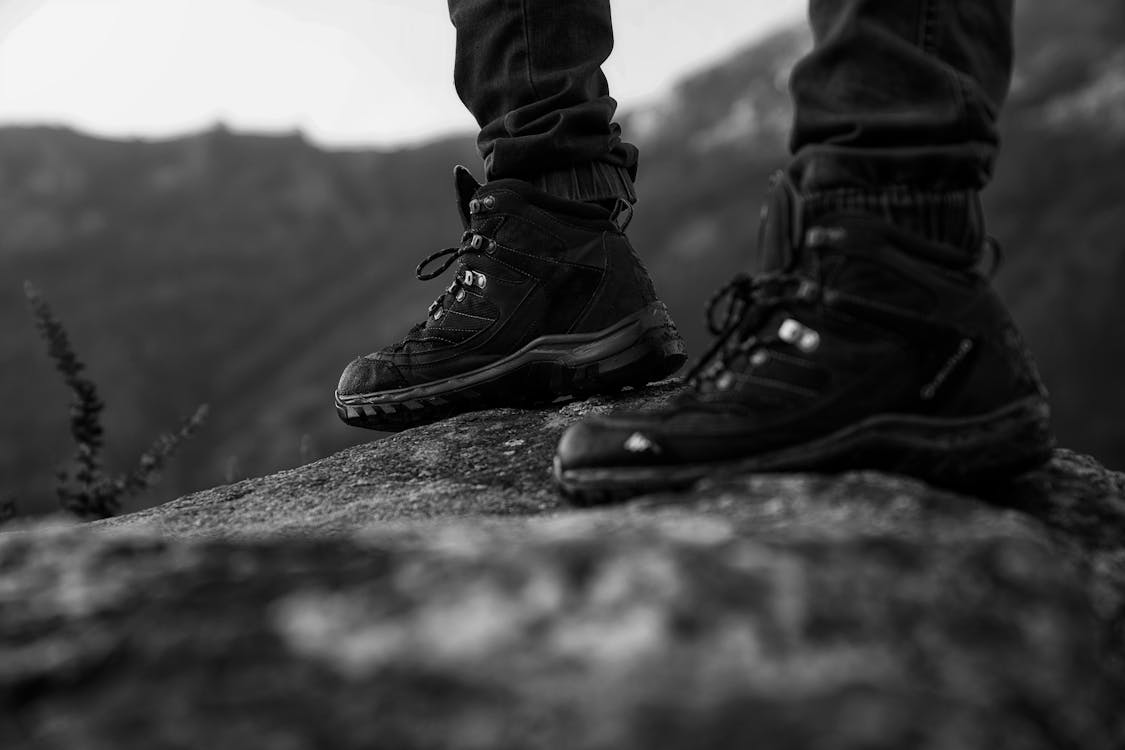 Monochrome Photo of Person Wearing Black Shoes