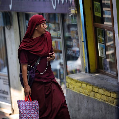 Man With Red Hijab Walking Past Store